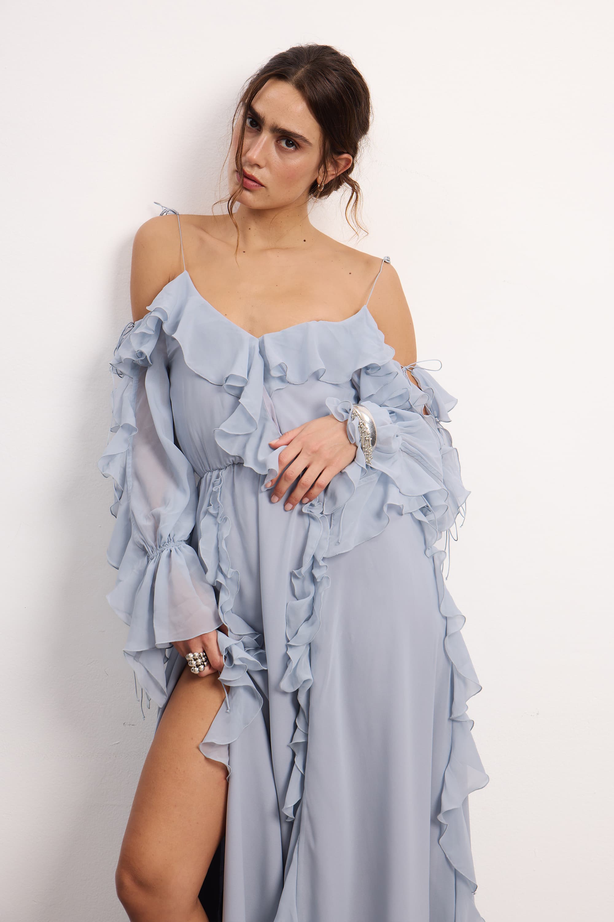 Woman wearing a blue fog off-shoulder ruffled Morning Forest midi dress on a white background, front view