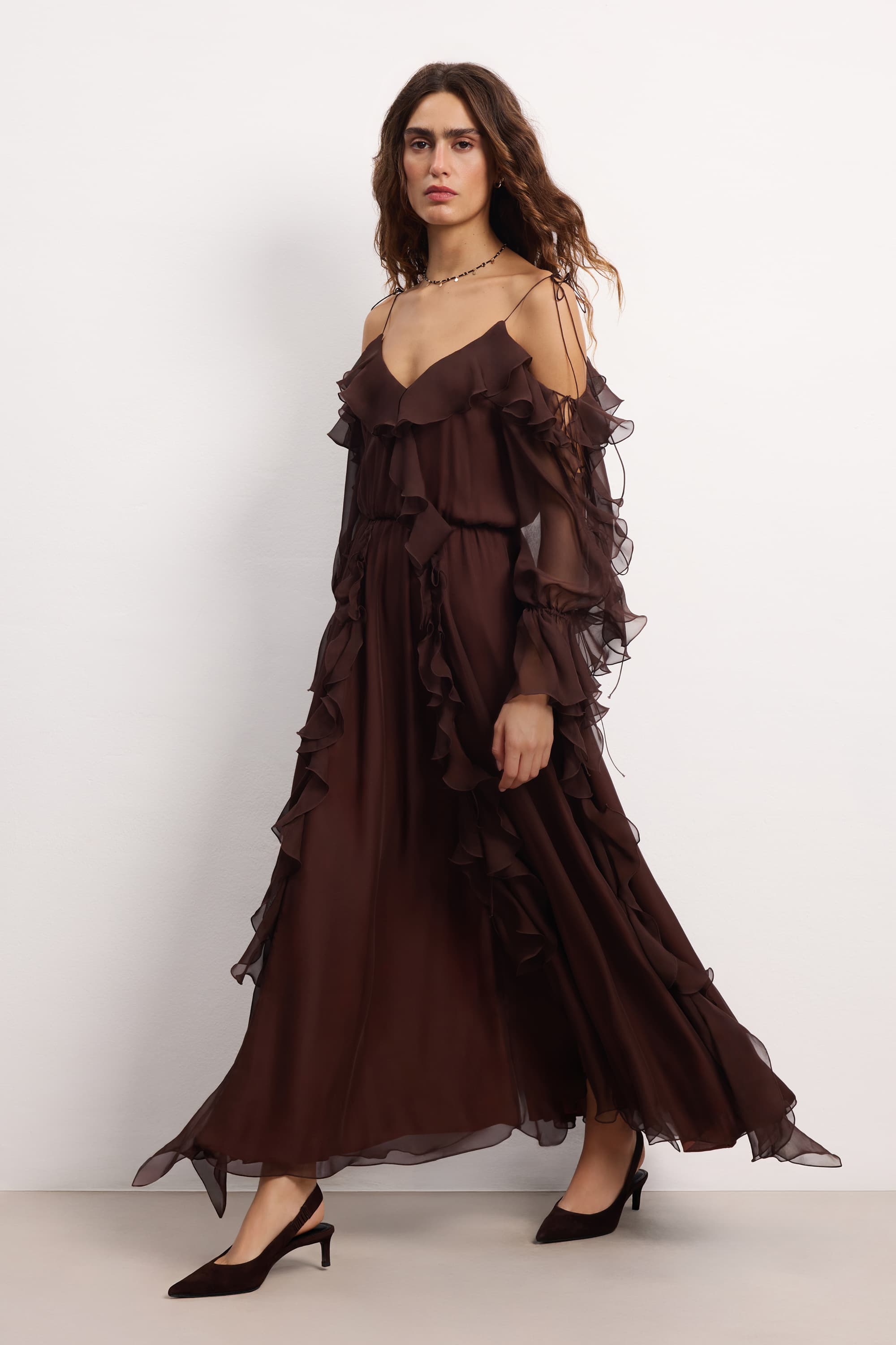 Woman wearing a brown off-shoulder ruffled Morning Forest midi dress on a white background, front view