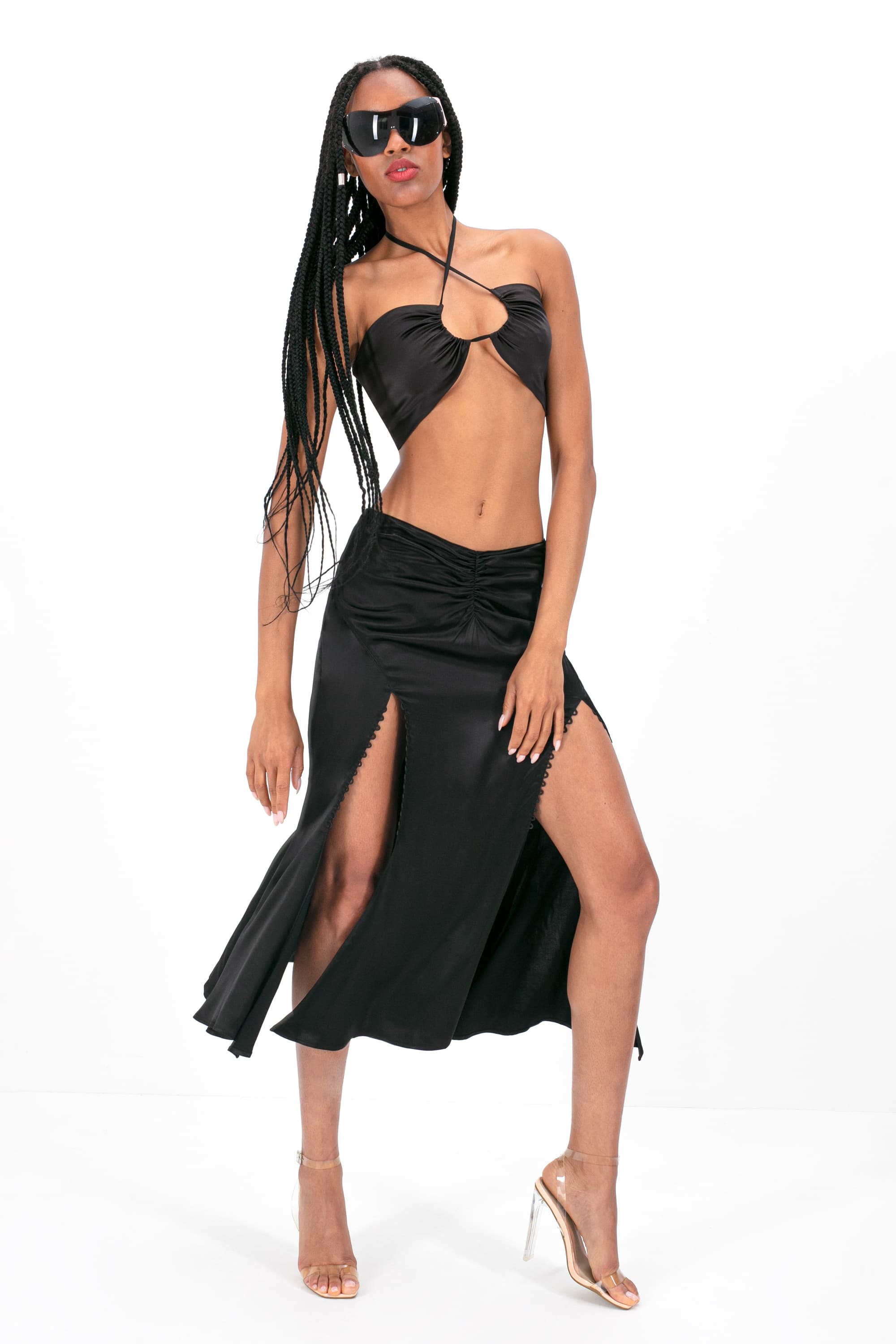 Woman wearing black Andromeda skirt standing against white background, front view